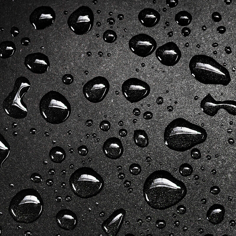 Close-up of water droplets beading on a smooth black surface, suggesting water resistance.